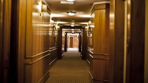 A long, narrow hallway with wooden paneling and a patterned carpet. - Hotel Remanso (Punta del Este)
