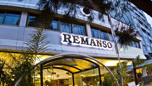 A hotel entrance with a glass canopy and potted plants. - Hotel Remanso (Punta del Este)