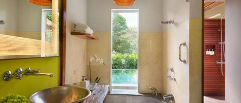 A modern bathroom with a large freestanding bathtub, a wooden vanity, and a large mirror.