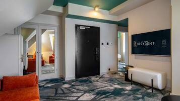 A hotel lobby with a modern design, including a patterned carpet, a bench, and a wall-mounted sign.
