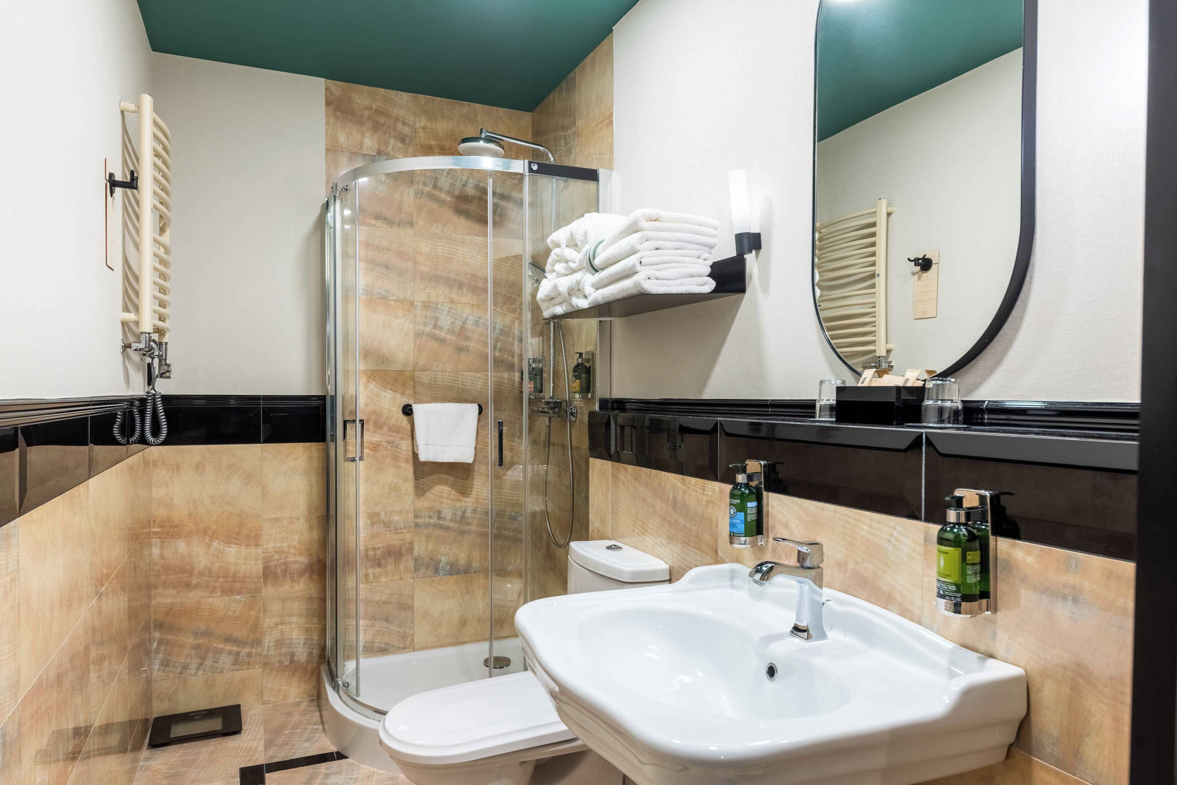 Ein modernes Badezimmer mit einer Glaskabine zur Dusche, einem weißen Waschbecken und einer Toilette.