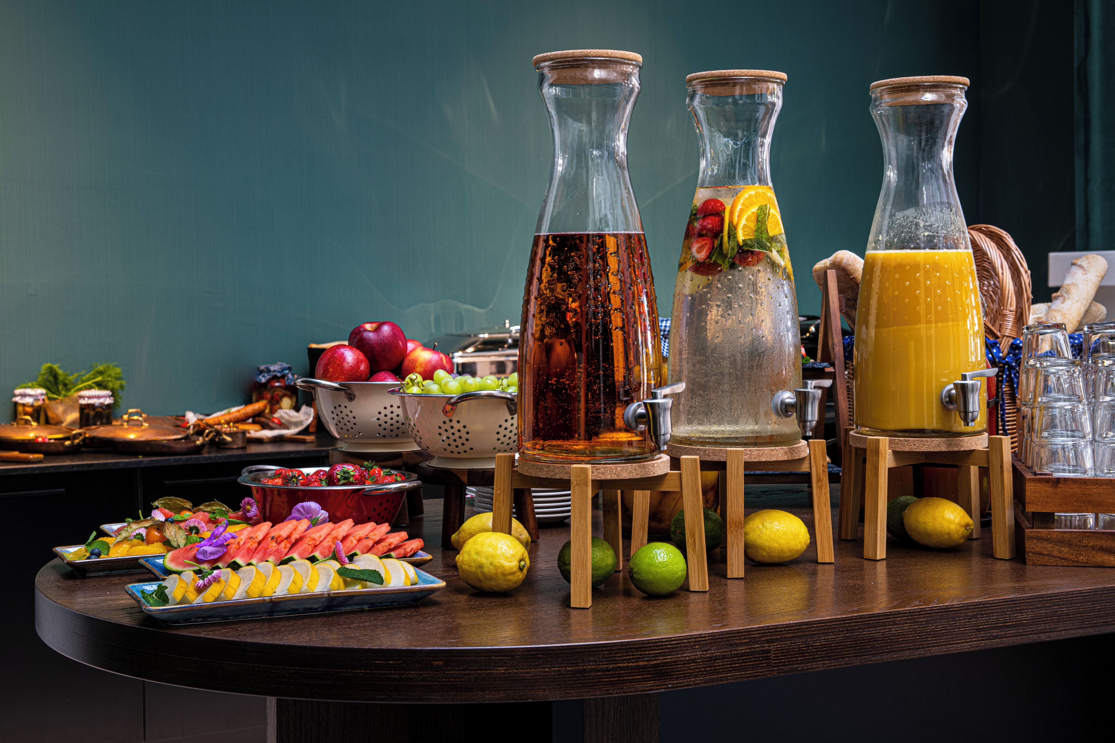 A buffet table with various fruits, vegetables, and beverages.