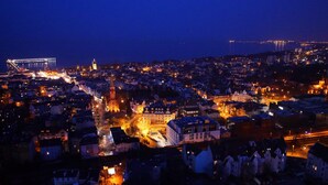 A nighttime cityscape with illuminated buildings and a prominent church tower. - Rezydent Hotel Sopot - MGallery Collection (Sopot)