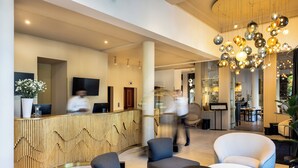 A modern lobby with a reception desk, seating area, and a staircase. - Rezydent Hotel Sopot - MGallery Collection (Sopot)