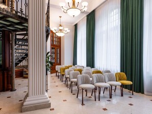 A grand hall with a marble floor, rows of chairs, a staircase, and a chandelier. - Rezydent Hotel Sopot - MGallery Collection (Sopot)