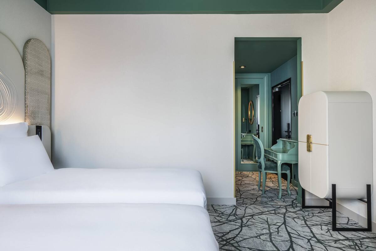 Ein Hotelzimmer mit einem Bett, einem Schreibtisch und einem Stuhl.