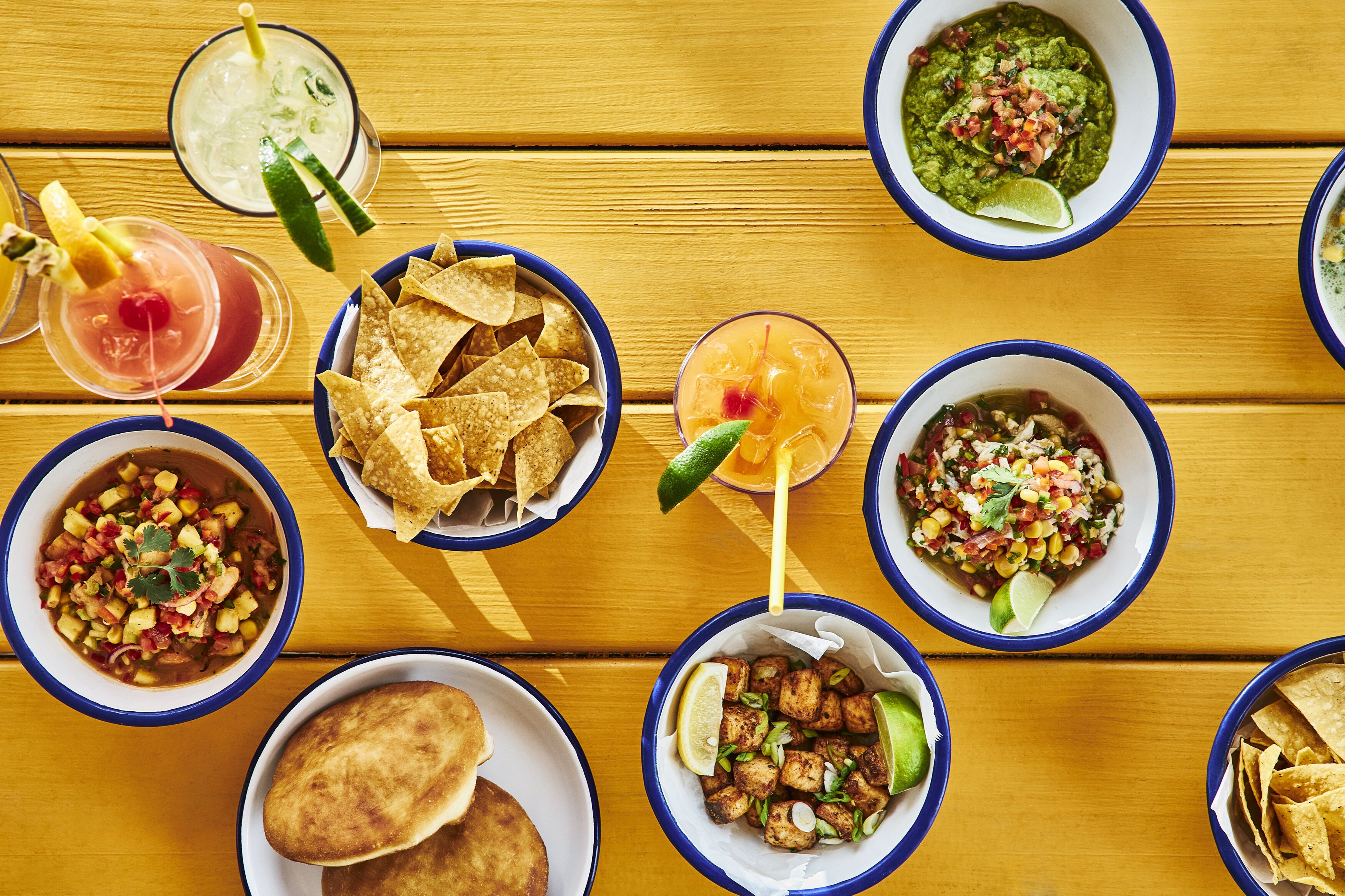 A variety of dishes and drinks on a wooden table.