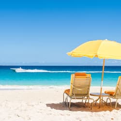 Aan een privéstrand, wit zand, ligstoelen, parasols