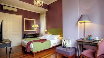 A hotel room with a bed, bedside table, chair, desk, and a mirror on the wall.