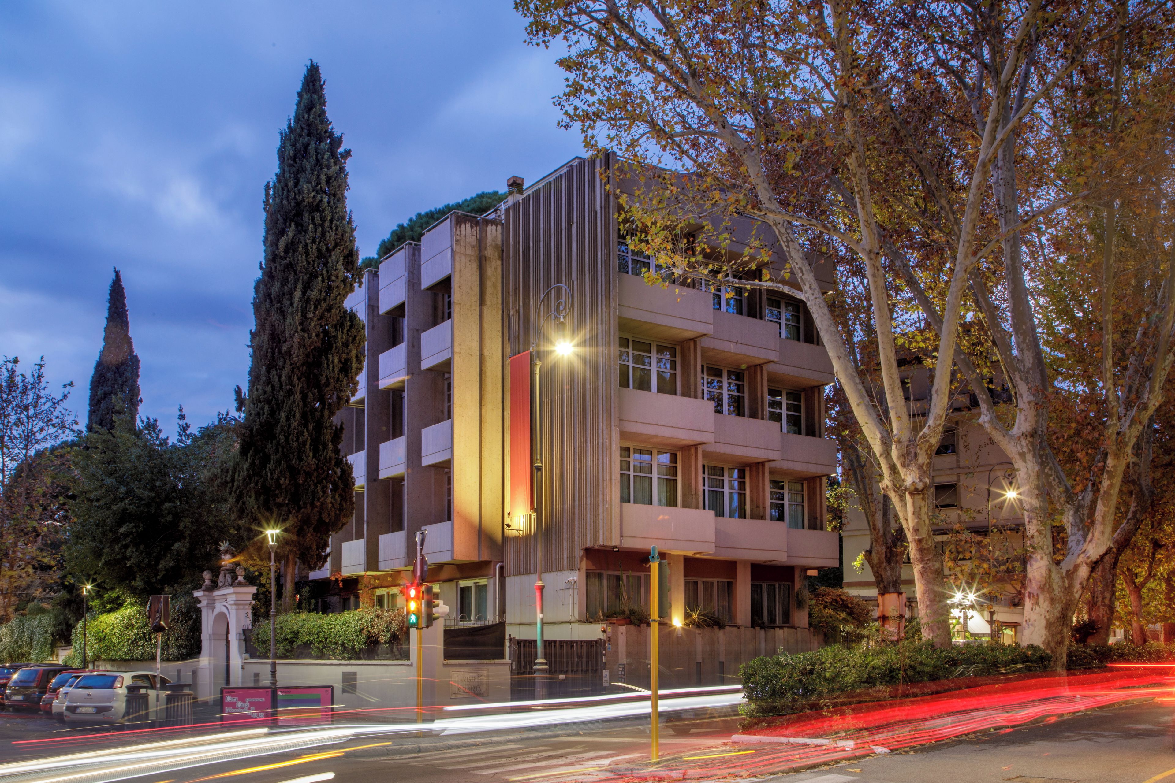 A multi-story building with a modern architectural design, featuring balconies and large windows.