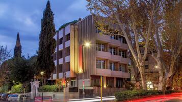 A multi-story building with a modern architectural design, featuring balconies and large windows.