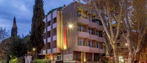 A multi-story building with a modern architectural design, featuring balconies and large windows.