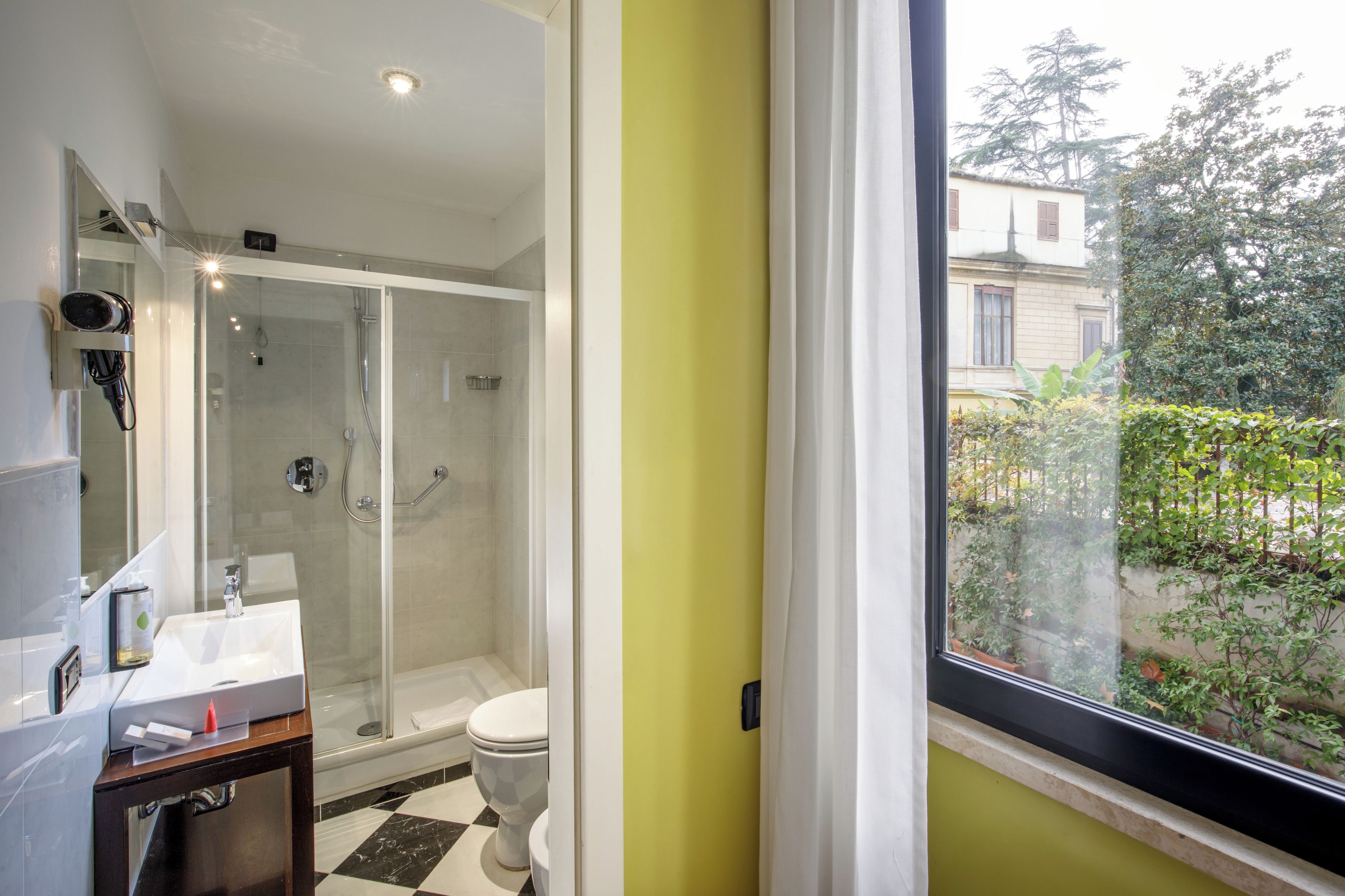 A bathroom with a glass shower enclosure, a white toilet, and a sink with a mirror.