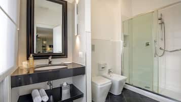 Ein modernes Badezimmer mit großem Spiegel, schwarzem Waschtisch, Bidet und einer Duschkabine.