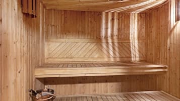 Uma sala de sauna com paredes e bancos de madeira.