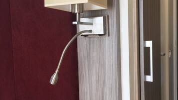 A wall-mounted light fixture with a rectangular shade, a flexible metal arm, and a control switch.