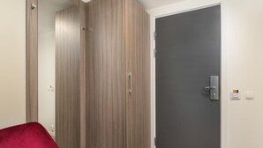 Une pièce avec une armoire, une porte et une chaise rouge.