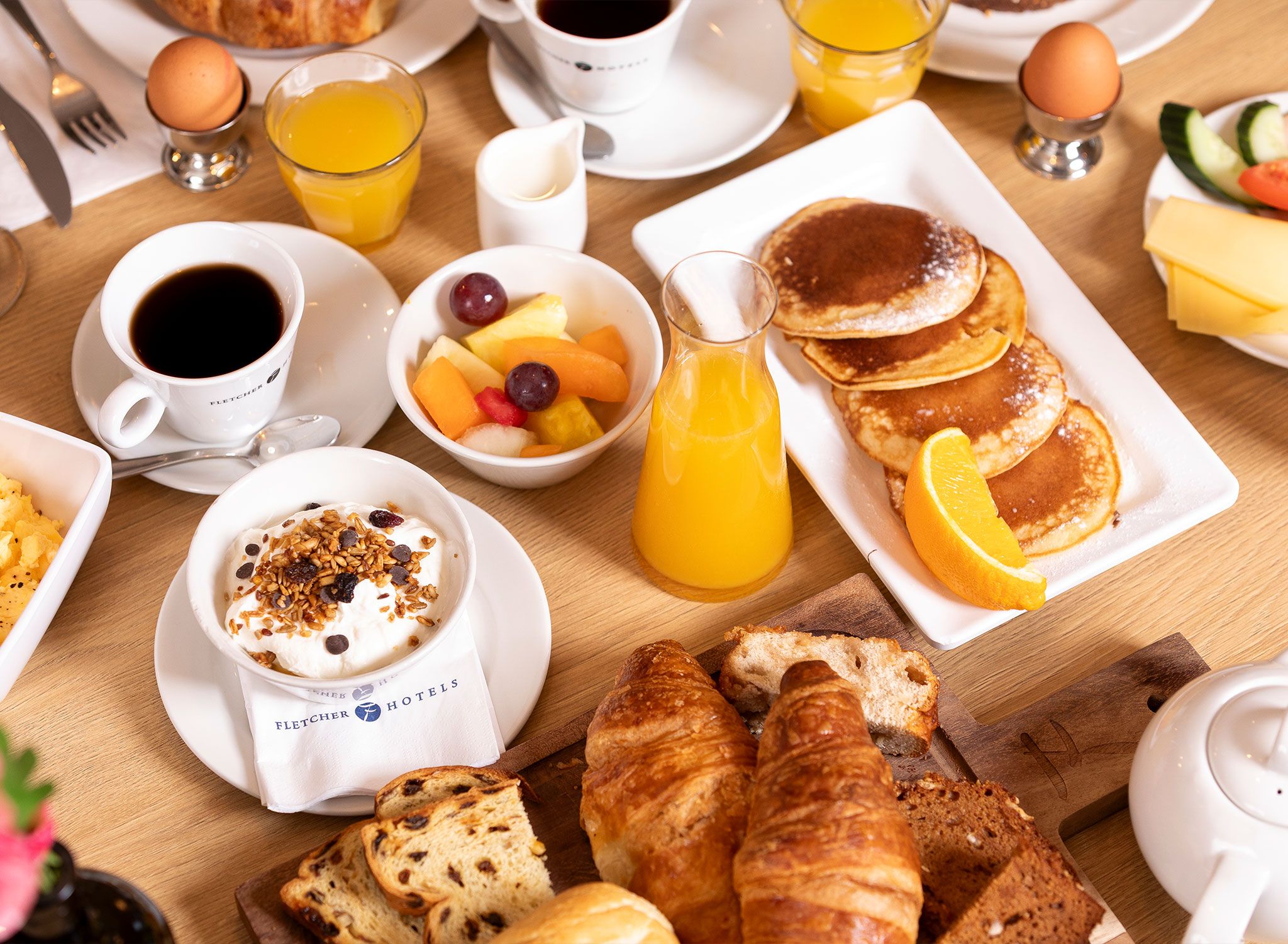 A breakfast setting with various food items and drinks.