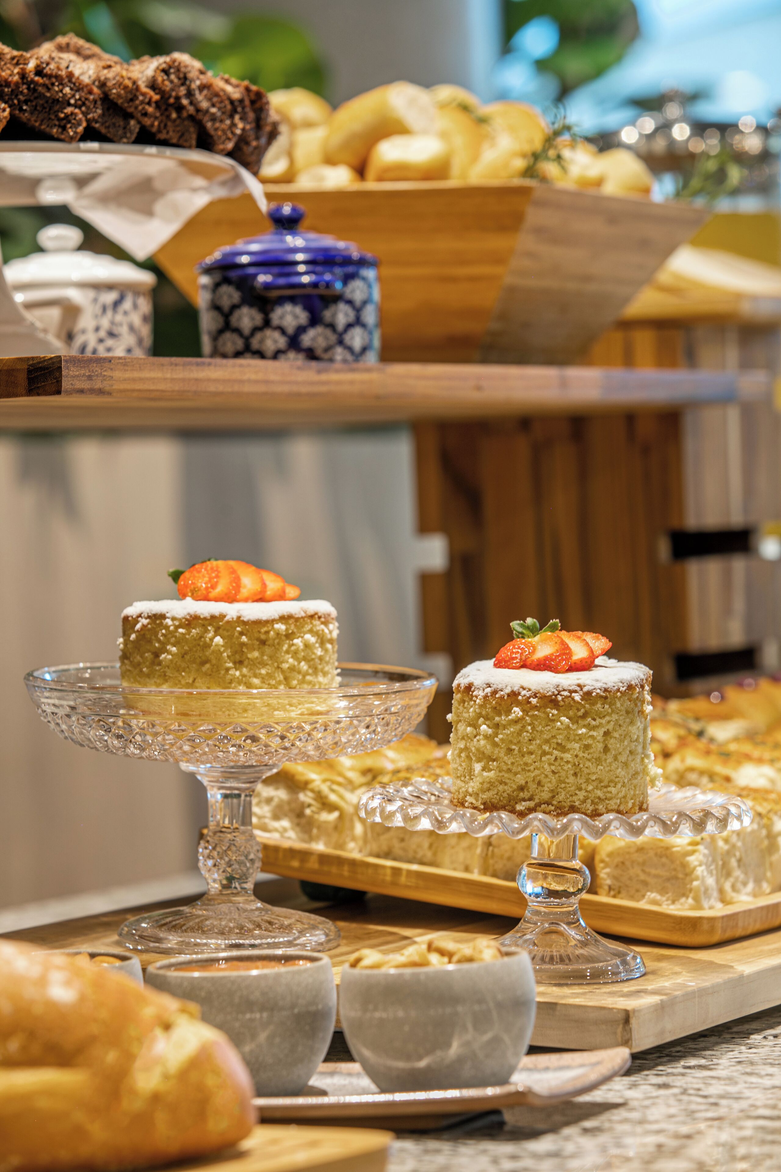 Een buffet met diverse gebakjes en desserts, waaronder taarten en gebak, gepresenteerd op houten etagères.