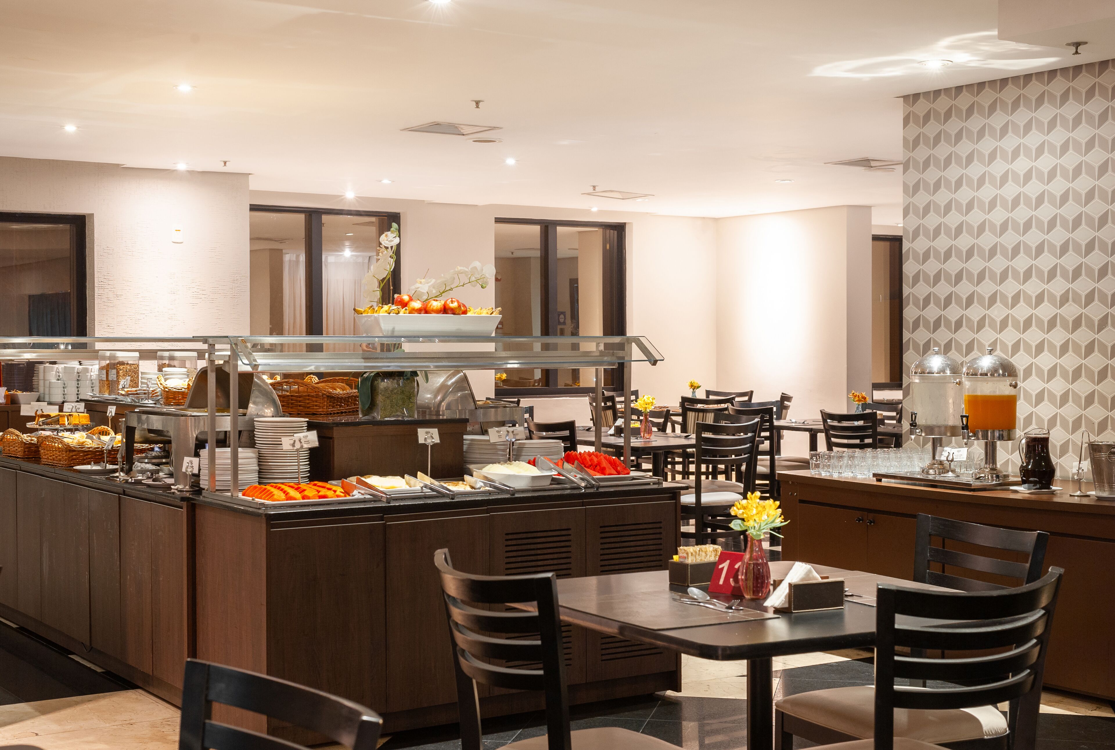 A buffet area with various food items and a seating area with tables and chairs.