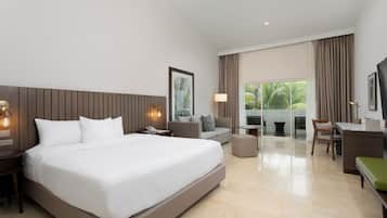 Una habitación de hotel moderna con una cama grande, un escritorio, un sofá y un balcón con cortinas.