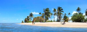 Am Strand, weißer Sandstrand, Liegestühle, Sonnenschirme