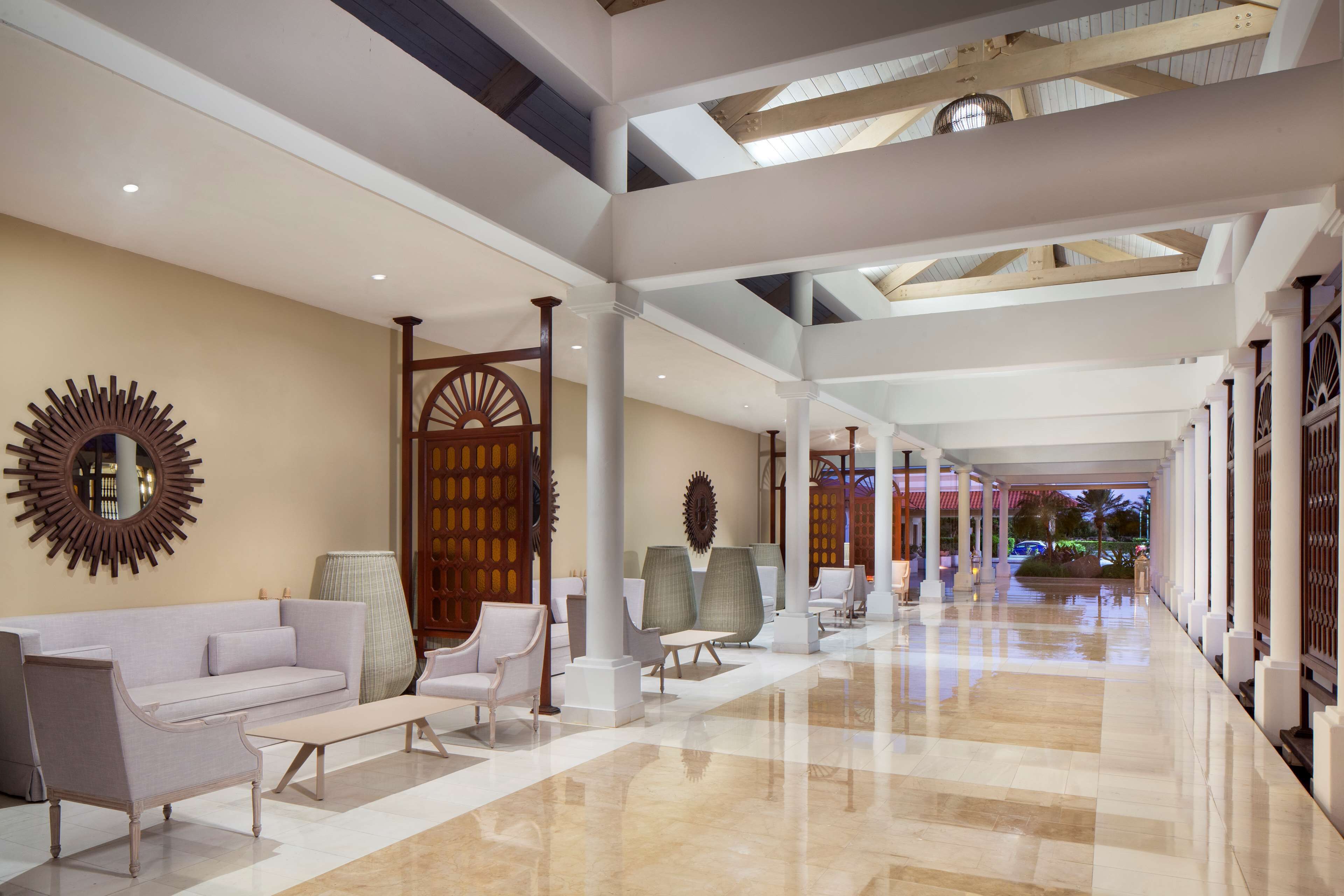 Un hall d’entrée spacieux avec un plafond haut, un mobilier moderne et une vue sur l’extérieur.
