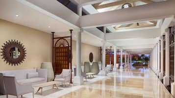 A spacious lobby with a high ceiling, modern furniture, and a view of the outdoors.