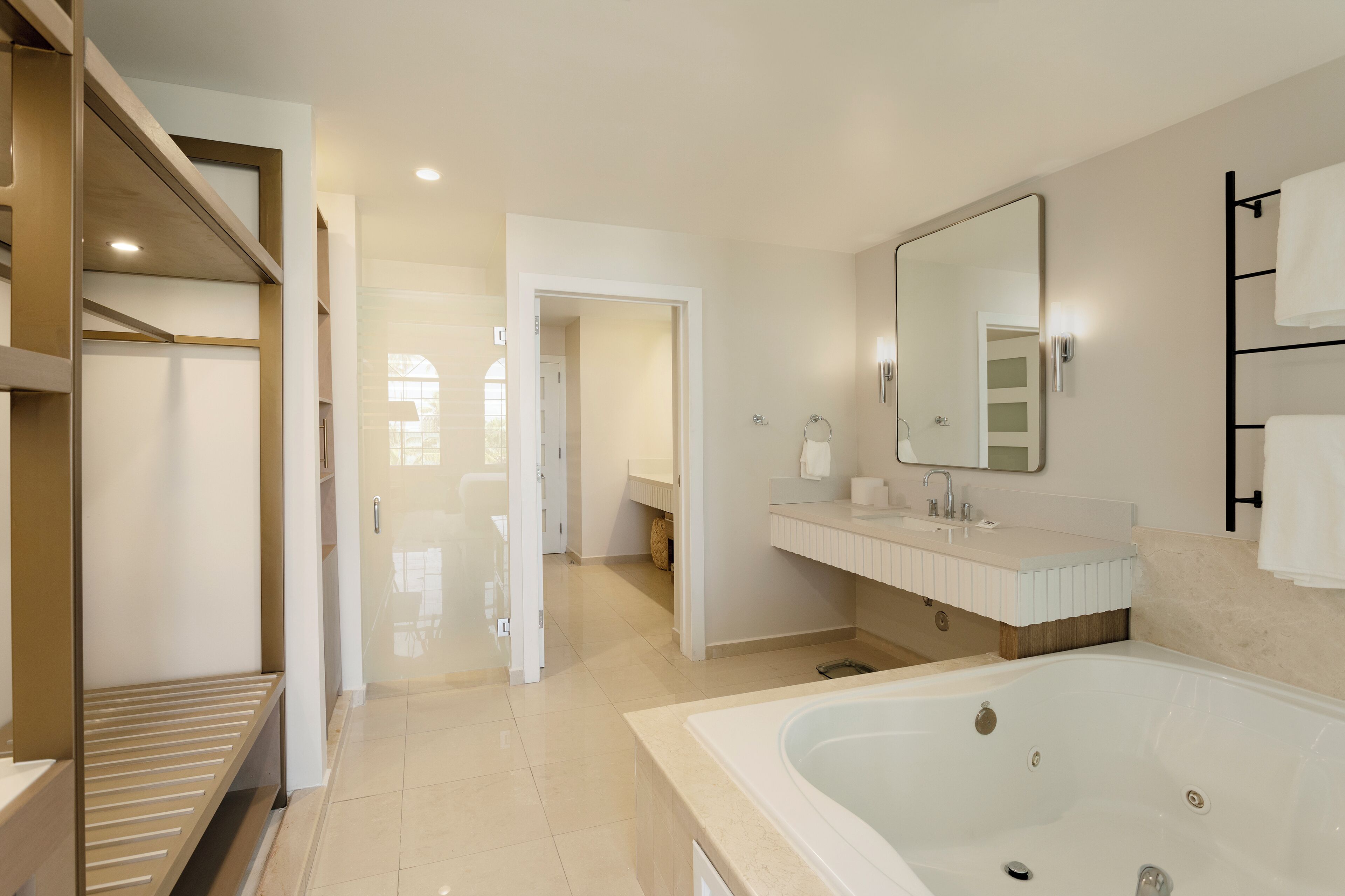 Un baño moderno con una bañera grande, una ducha a pie y un tocador con espejo.