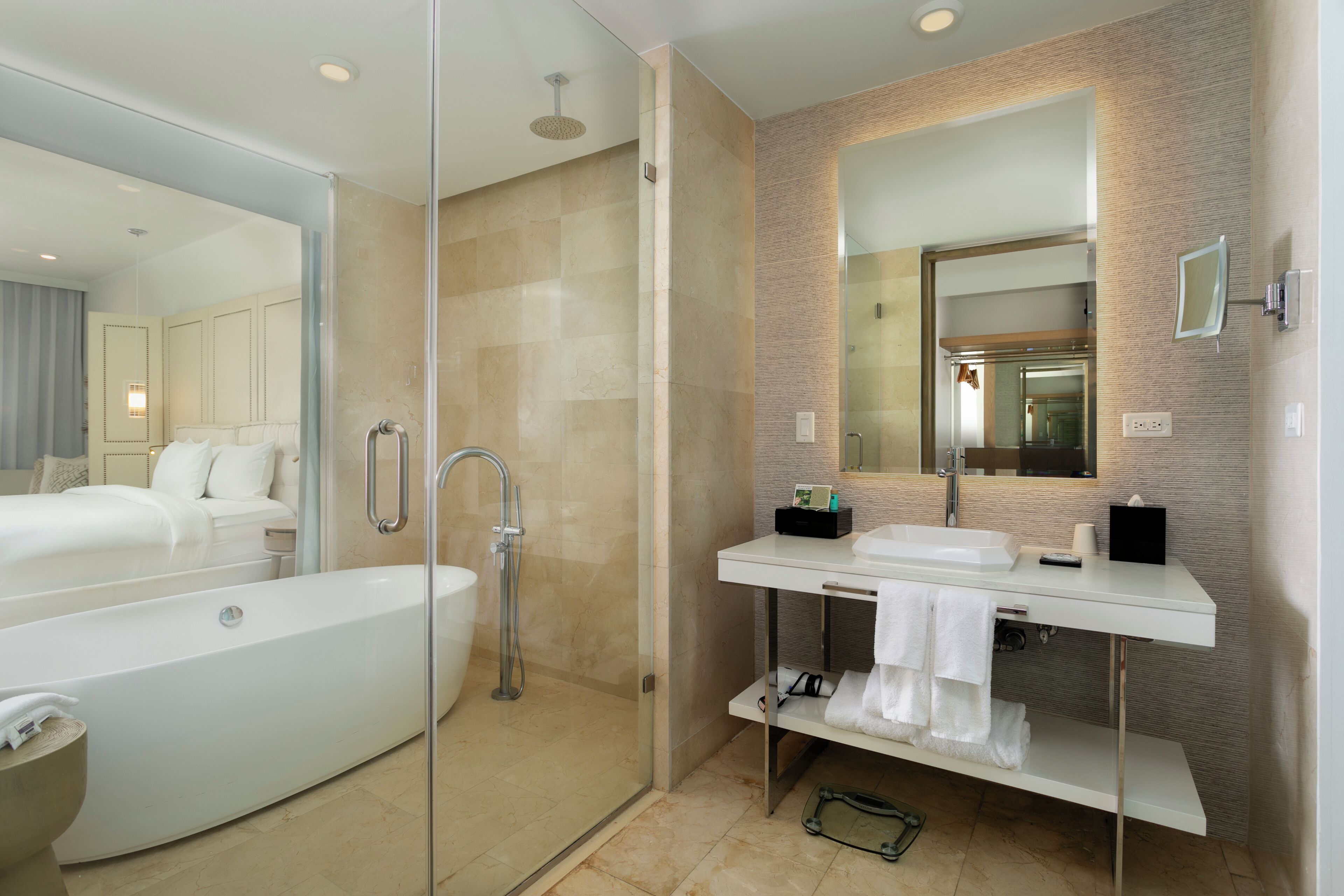 Un baño moderno con ducha de vidrio, una bañera independiente y un tocador con espejo.