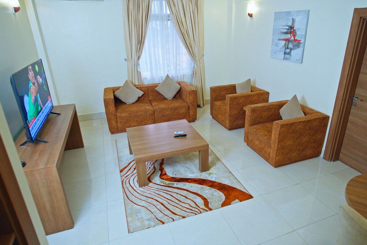 A living room with a sofa set, a coffee table, and a television.
