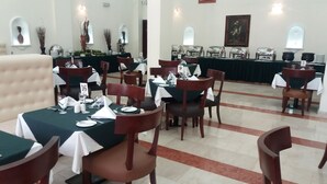 A dining area with tables set for guests, numbered place cards, and a buffet line in the background. - Stratton Hotel Asokoro (Abuja)
