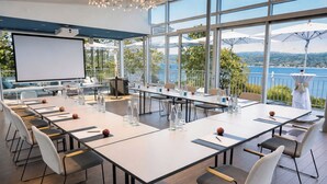 A conference room with a large table, chairs, and a projector screen.
