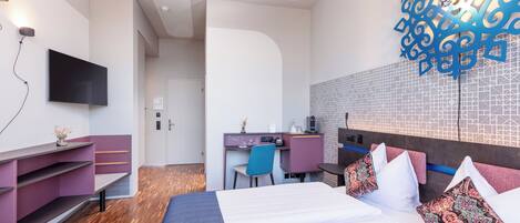 Una habitación de hotel moderna con cama, escritorio y zona de estar.