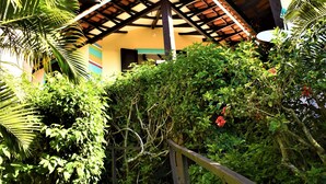A staircase leading to a building with a tiled roof, surrounded by lush greenery and a clear blue sky. - Hibiscus Beach Pousada (Búzios)
