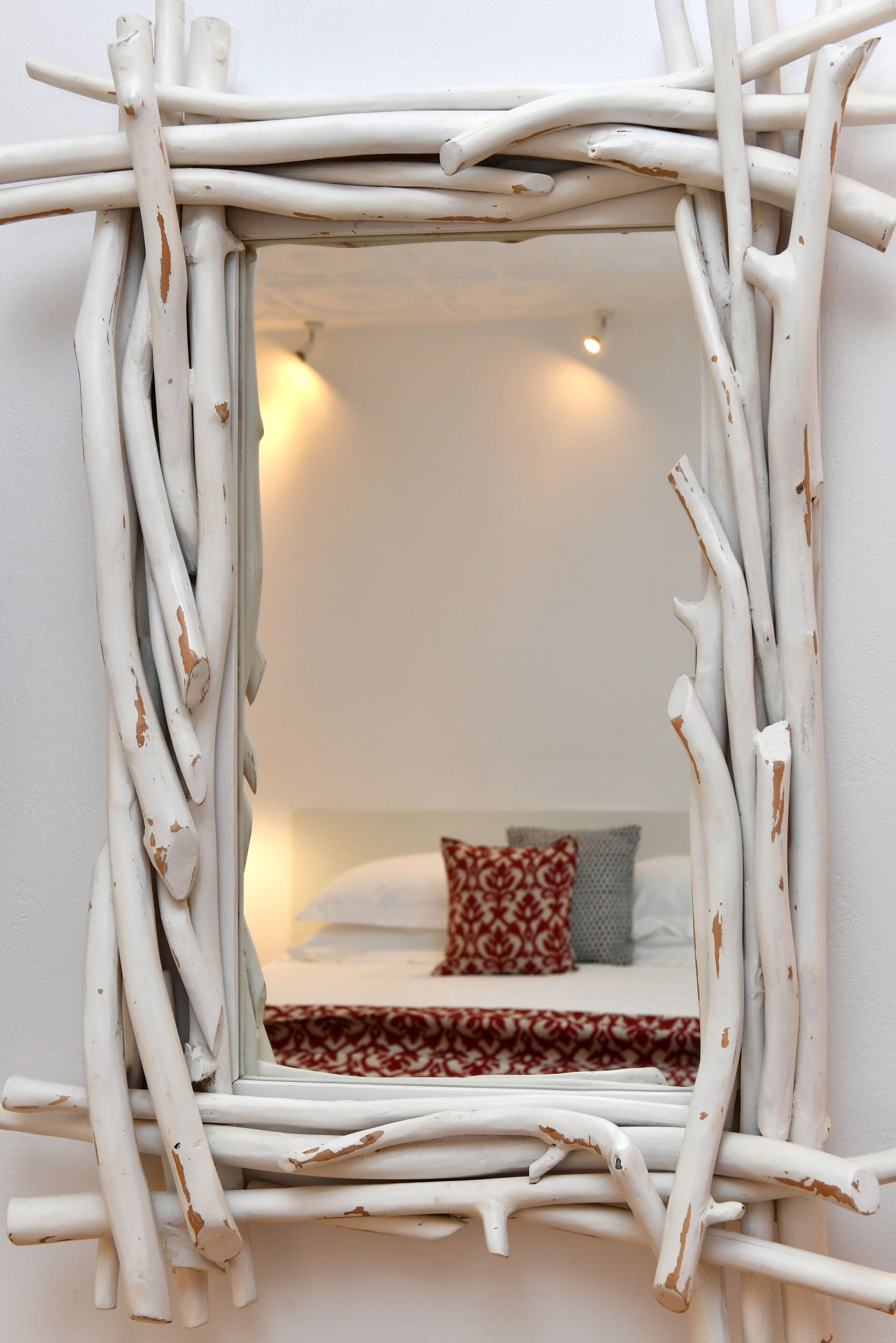 A mirror with a rustic, white frame.