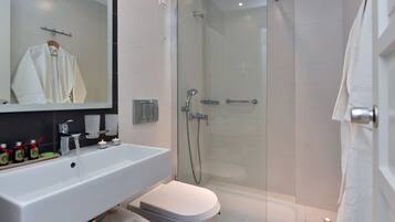 Une salle de bain moderne avec une douche à parois de verre, un lavabo blanc et des toilettes.