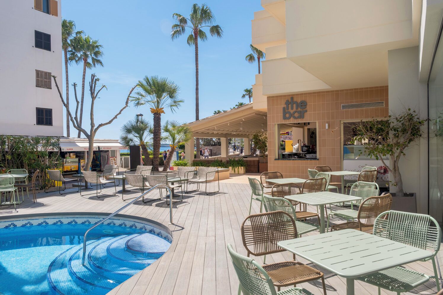 A poolside area with outdoor seating and a bar.