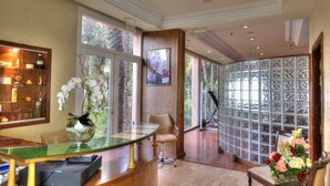 Un intérieur moderne avec une table en verre, une chaise, un vase de fleurs et une vue à travers une paroi vitrée.