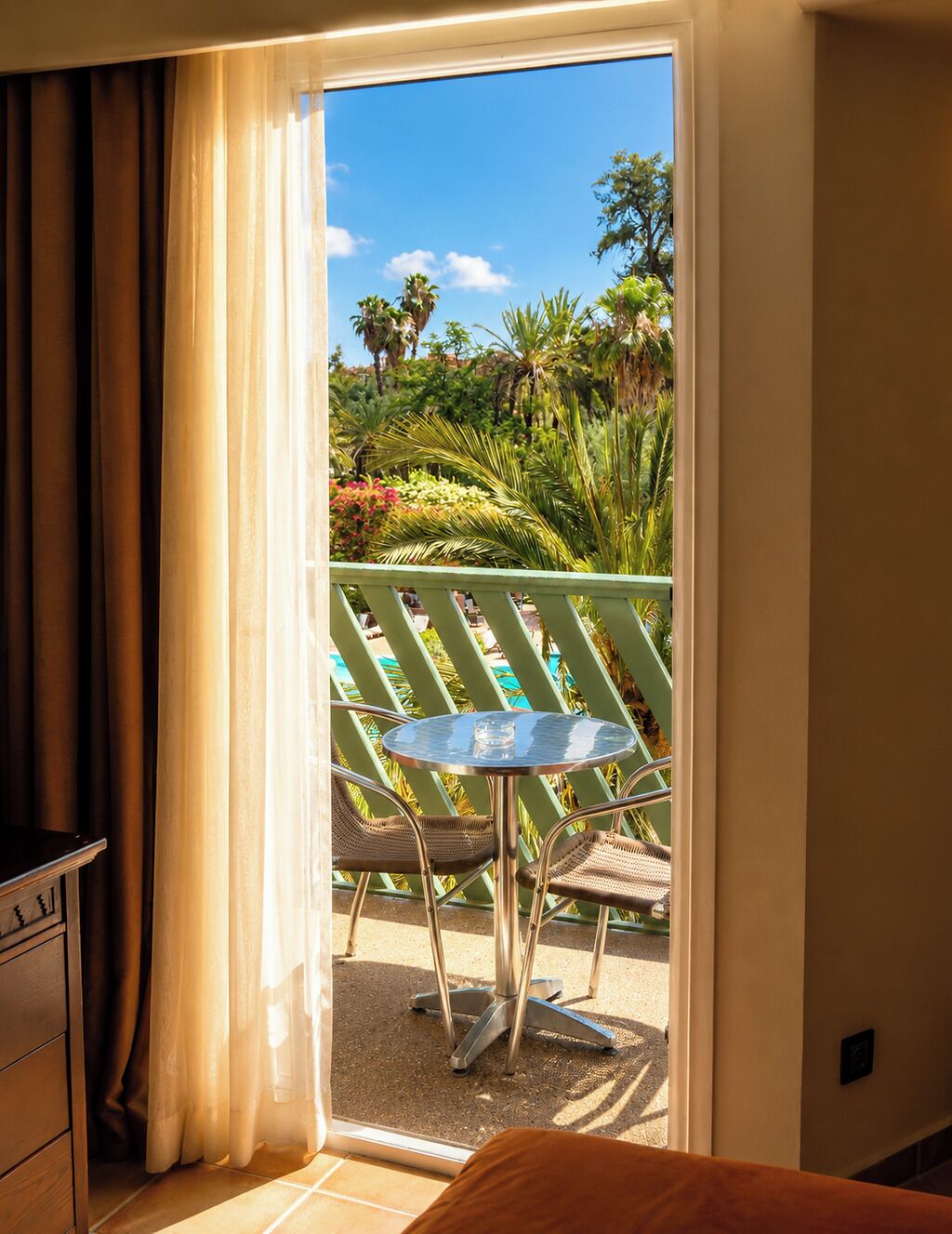A room with a sliding glass door leading to an outdoor area with a table and chairs.