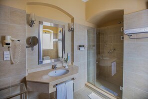 A modern bathroom with a sink, mirror, and shower.