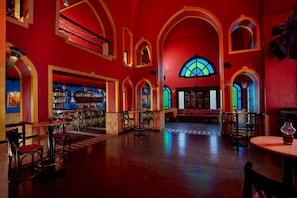 A bar area with wooden floors, red walls, and arched ceilings. - Iberotel Makadi Beach by JAZ - All inclusive (Makadi Bay)