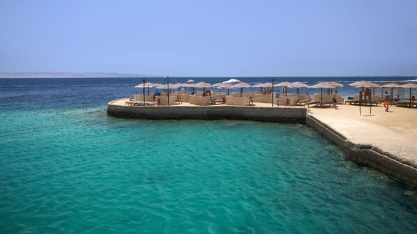 Een privéstrand, parasols, strandlakens, duiken