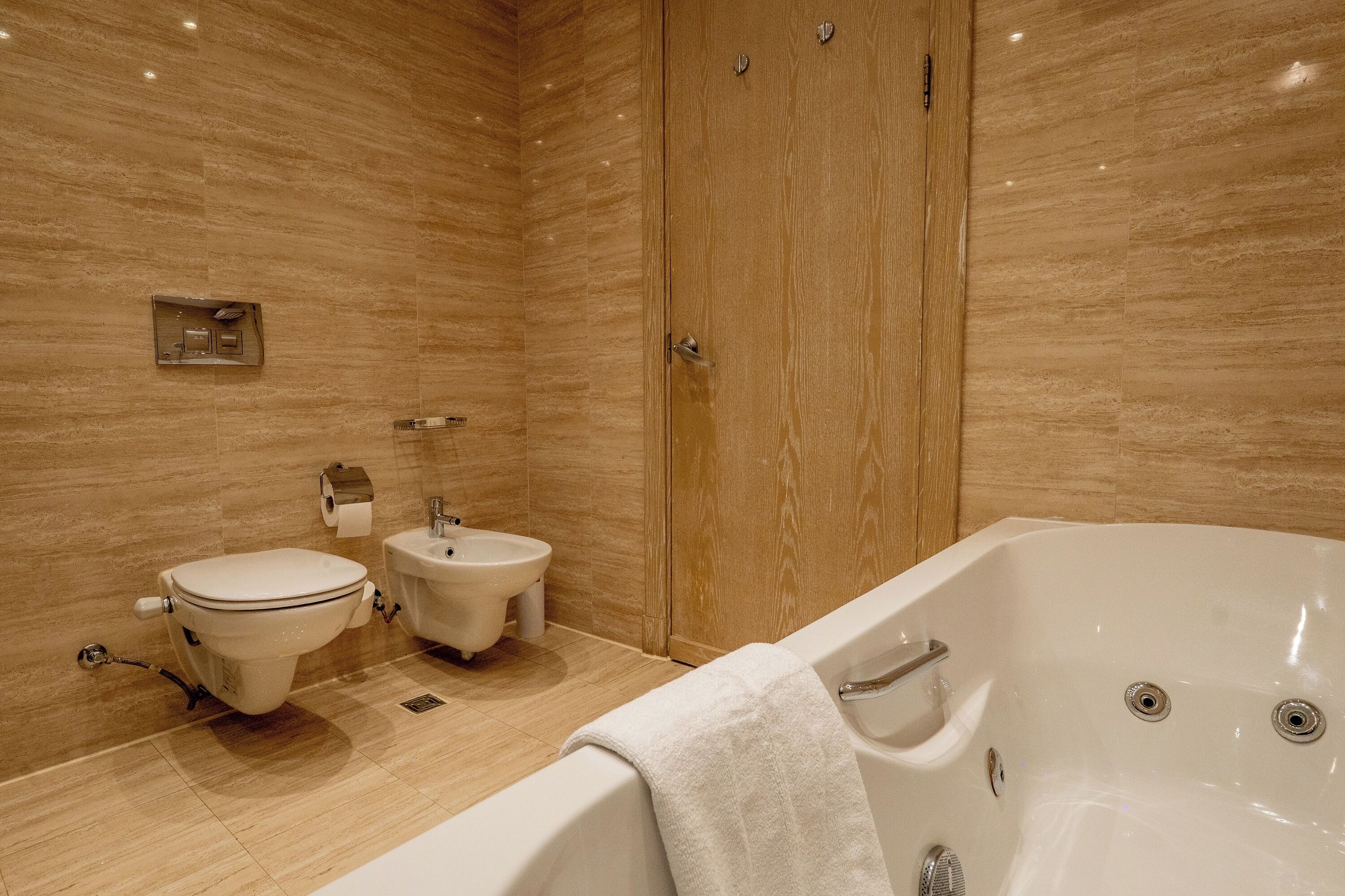A modern bathroom with a toilet, bidet, and bathtub.