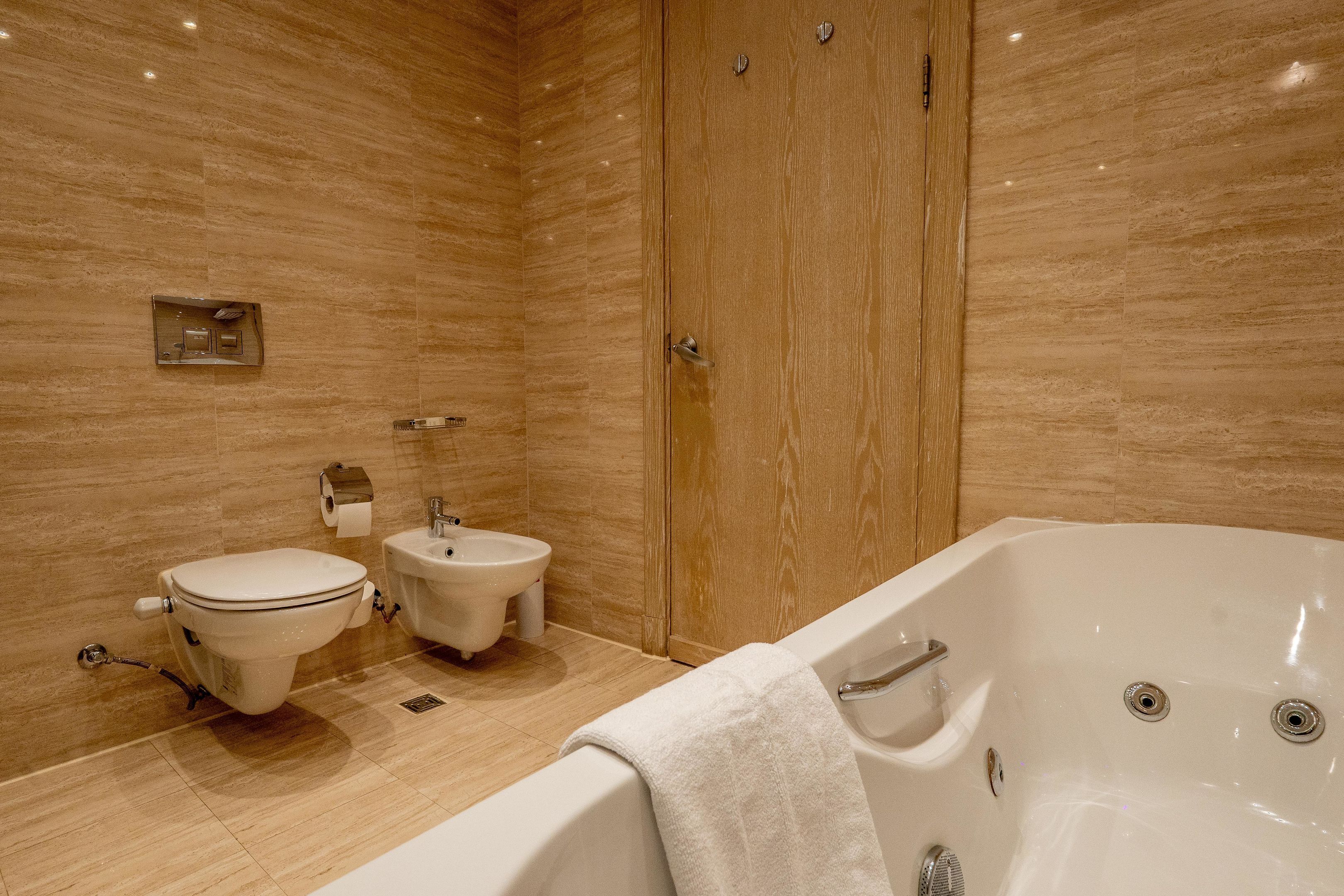 A bathroom with a toilet, bidet, and bathtub.