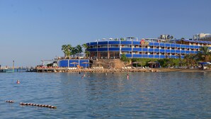 Un hotel grande de varios pisos con fachada azul, situado junto al agua.