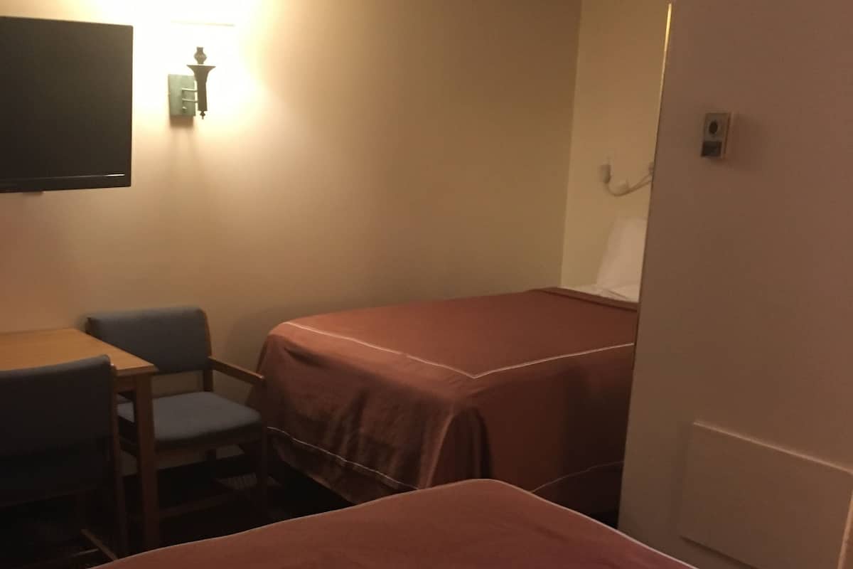 Una habitación con cama, escritorio y silla.