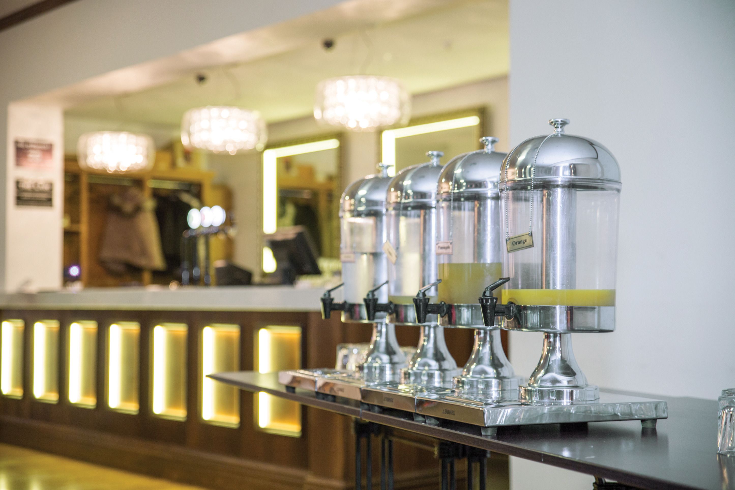 Eine Barbereich mit einer Reihe Kaffeeautomaten und einem Tresen mit beleuchteten Panels.