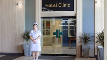 A hotel clinic entrance with a receptionist standing in front.