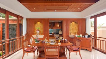 Un comedor amplio con una gran mesa de madera, sillas alrededor y vistas al exterior a través de amplios ventanales.